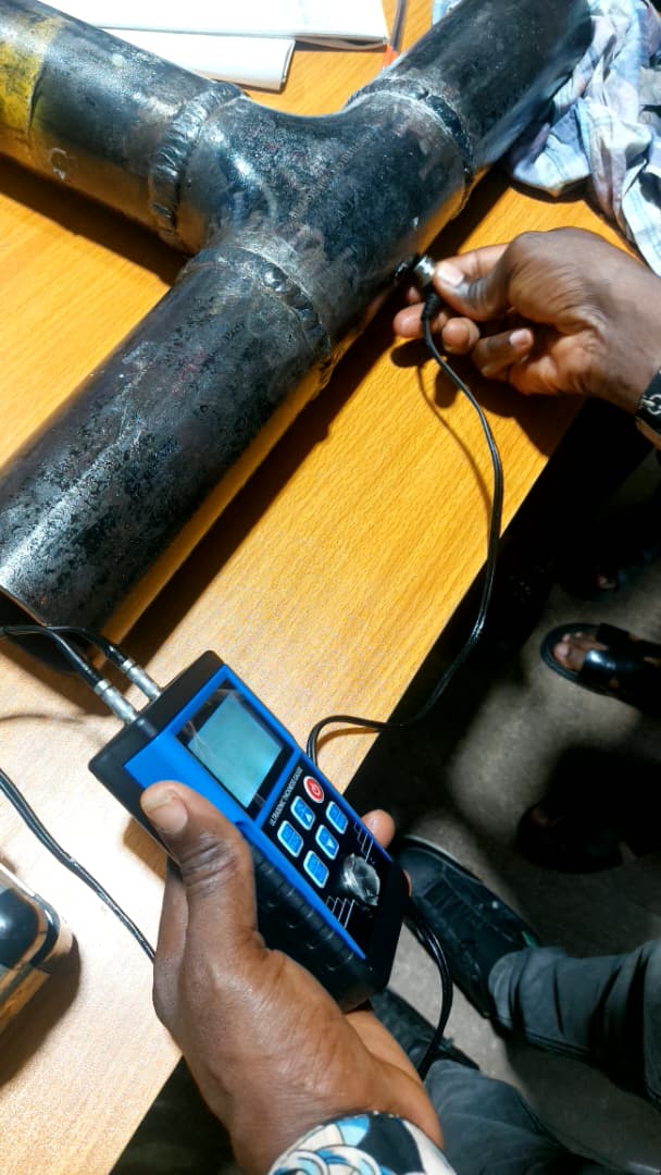 NDT technician testing pipe fitting